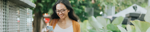 woman walking and looking at her phone